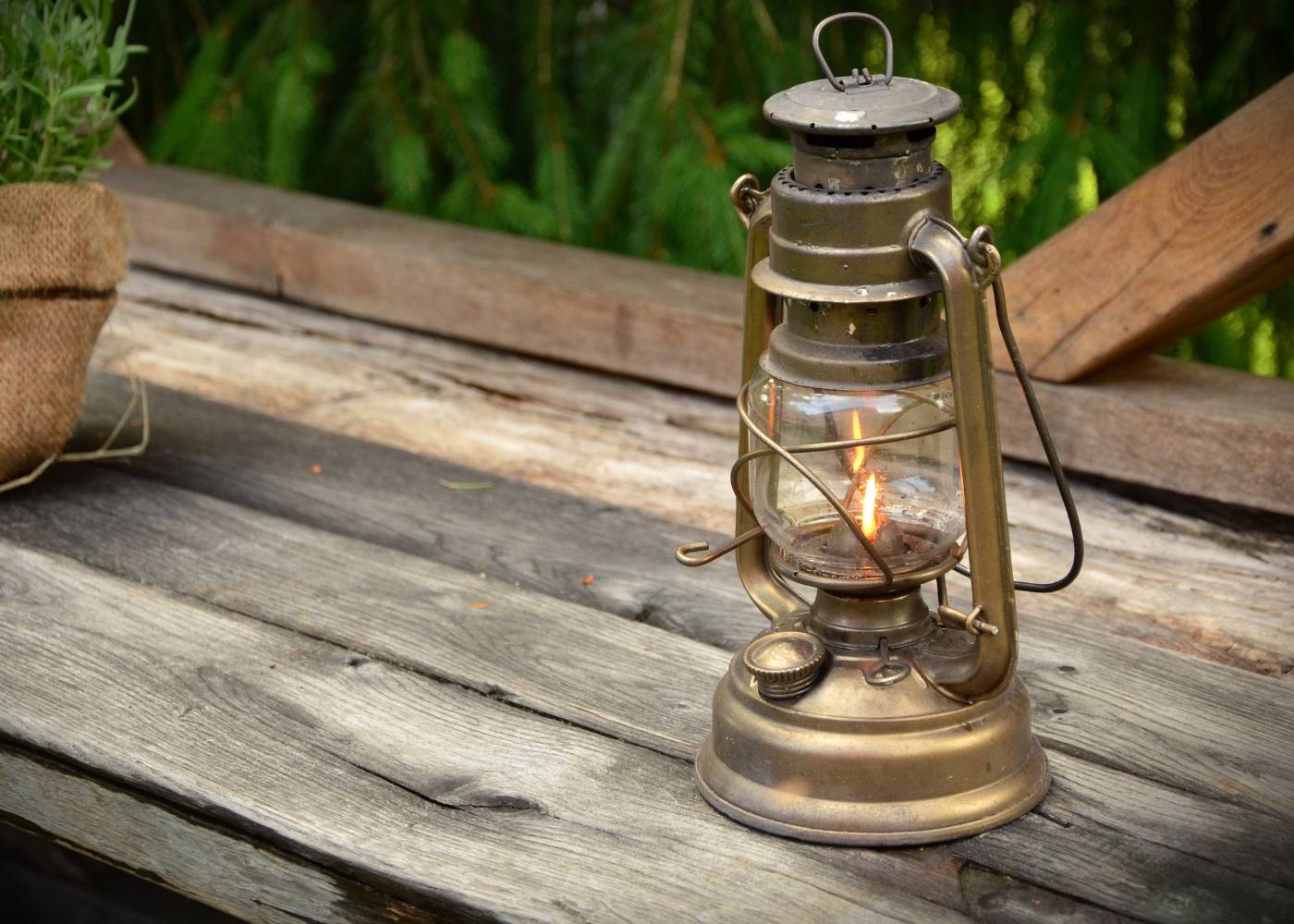 na zdjęciu lampa naftowa która stoi na stole drewnianym