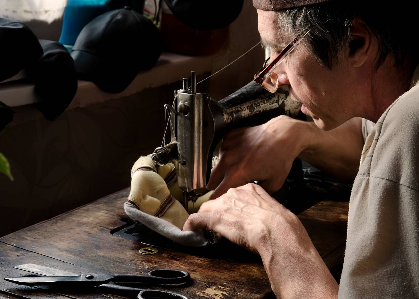 Na zdjęciu rzemieślnik szyjący na maszynie
