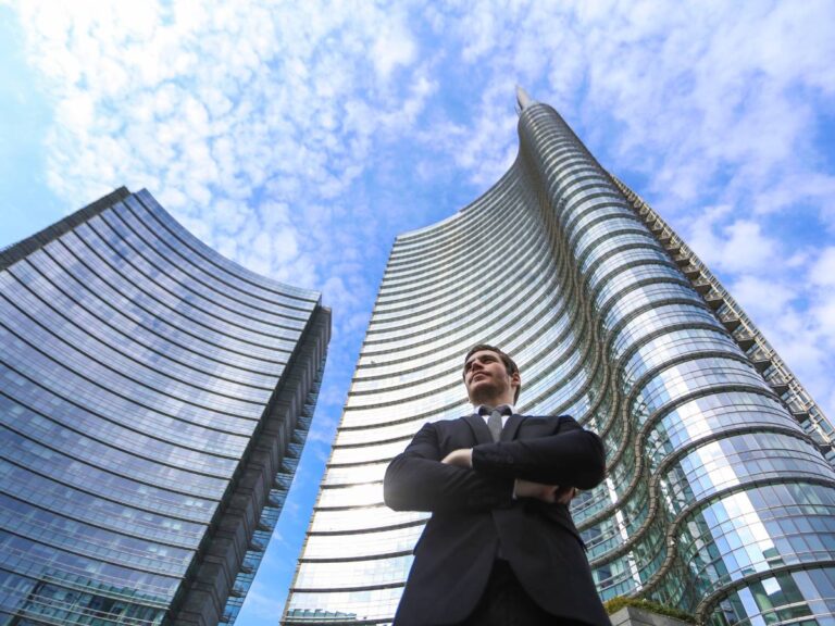 Mężczyzna na tle wieżowców. Obrazek w artykule Cechy osoby przedsiębiorczej. Co wyróżnia osoby odnoszące sukces?